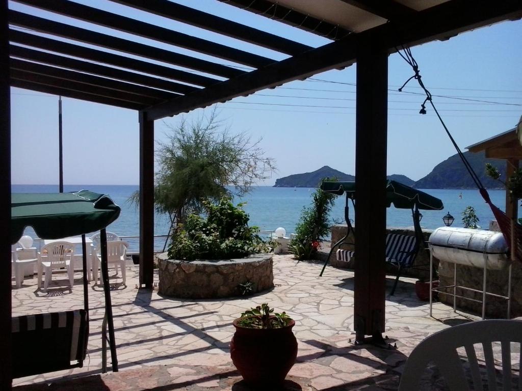 a patio with a view of the ocean at Evgenios Studios in Agios Georgios Pagon