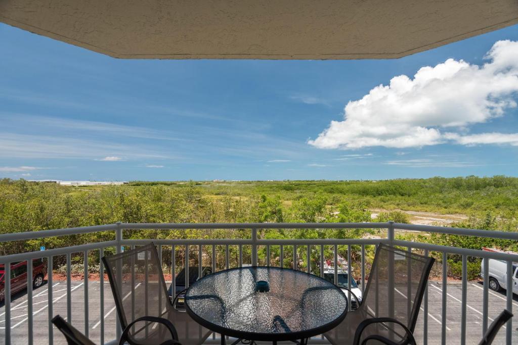 patio con mesa y sillas en el balcón en Sunrise Suites Catalina Suite #311, en Key West