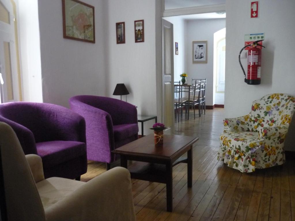 a living room with purple chairs and a table at Casa do Arco da Praça in Elvas