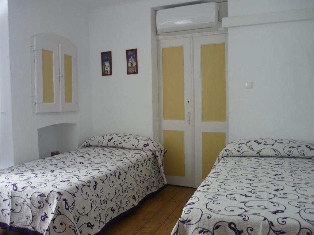 a bedroom with two beds and a door at Casa do Arco da Praça in Elvas