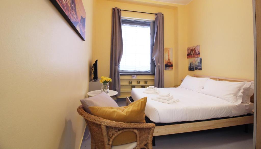 ein Schlafzimmer mit einem Bett mit einem Stuhl und einem Fenster in der Unterkunft Italianway-San Pietro all'Orto in Mailand