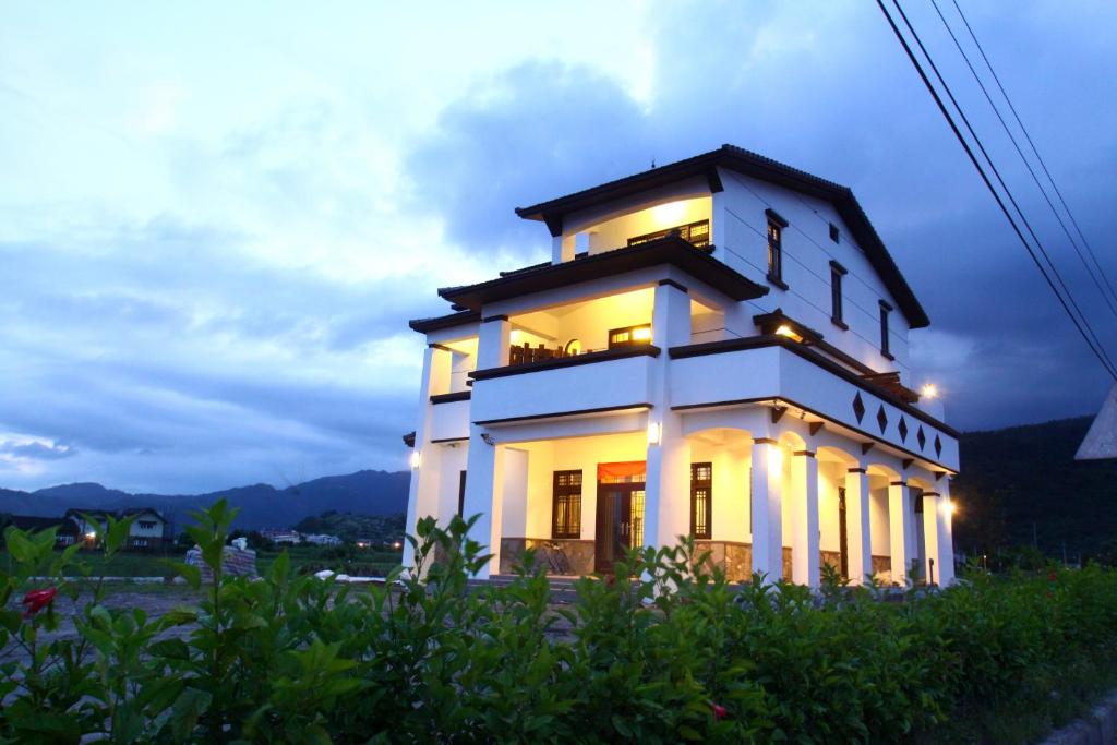 ein weißes Gebäude mit Lichtern darüber in der Unterkunft 愛樂耕民宿 Elegant Homestay in Yuanshan