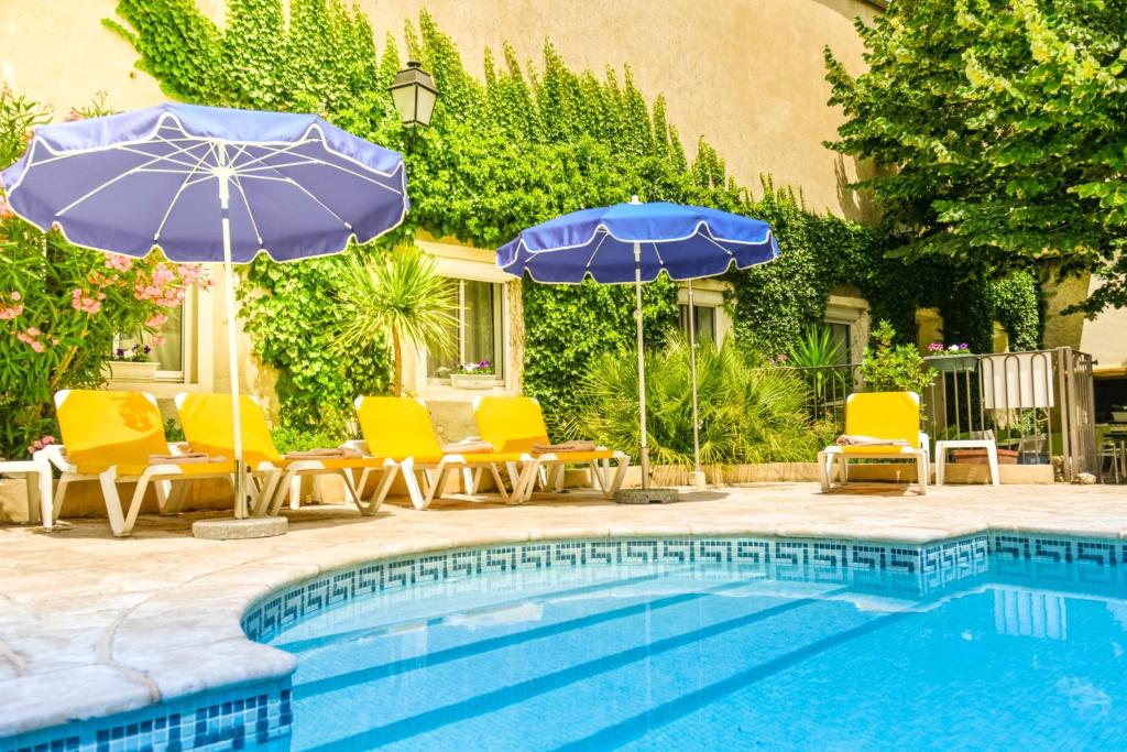 a swimming pool with chairs and umbrellas and a pool at Logis Hôtel Restaurant Résidence in Nissan-lez-Enserune
