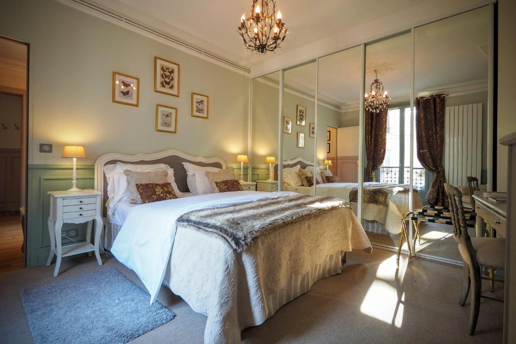 a bedroom with two beds and a chandelier at Chambre d hôte : Louvre Elegant Apt Suite in Paris