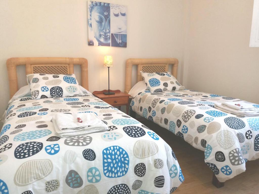 dwa łóżka ustawione obok siebie w sypialni w obiekcie Apartamento Ossuna w mieście La Laguna