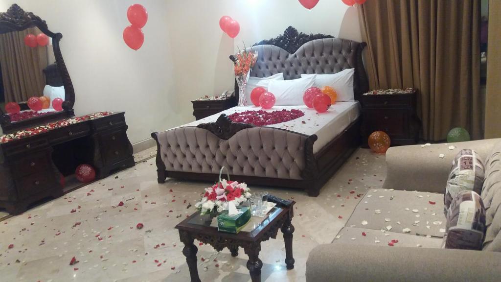 a bedroom with a bed and a table with balloons at Executive Galaxy Guest House in Islamabad