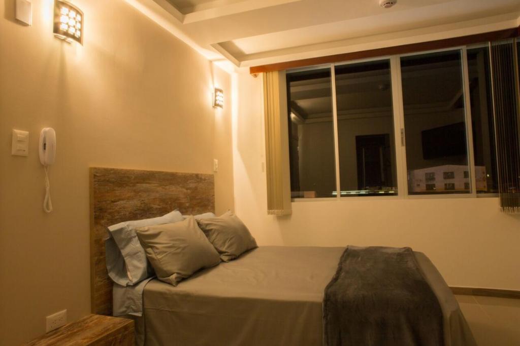 sypialnia z łóżkiem z telefonem na ścianie w obiekcie 212 Hotel w mieście Santa Rosa de Cabal