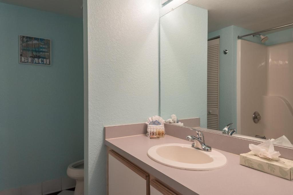 ein Bad mit einem Waschbecken und einem Spiegel in der Unterkunft Sunrise Suites Saint Lucia Suite #201 in Key West