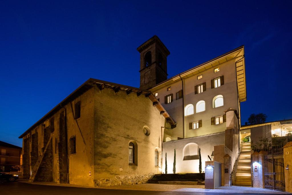 un bâtiment avec une tour d'horloge la nuit dans l'établissement La Ripa Boutique Hotel, à Albino