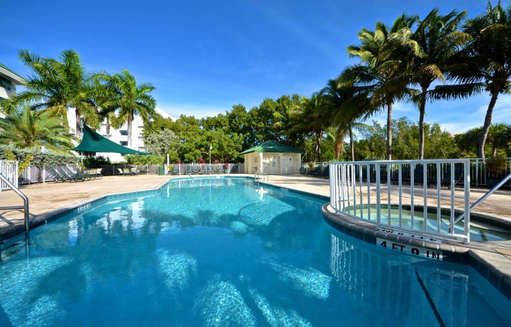una gran piscina con palmeras en el fondo en Sunrise Suites Cayo Coco Suite #208, en Key West