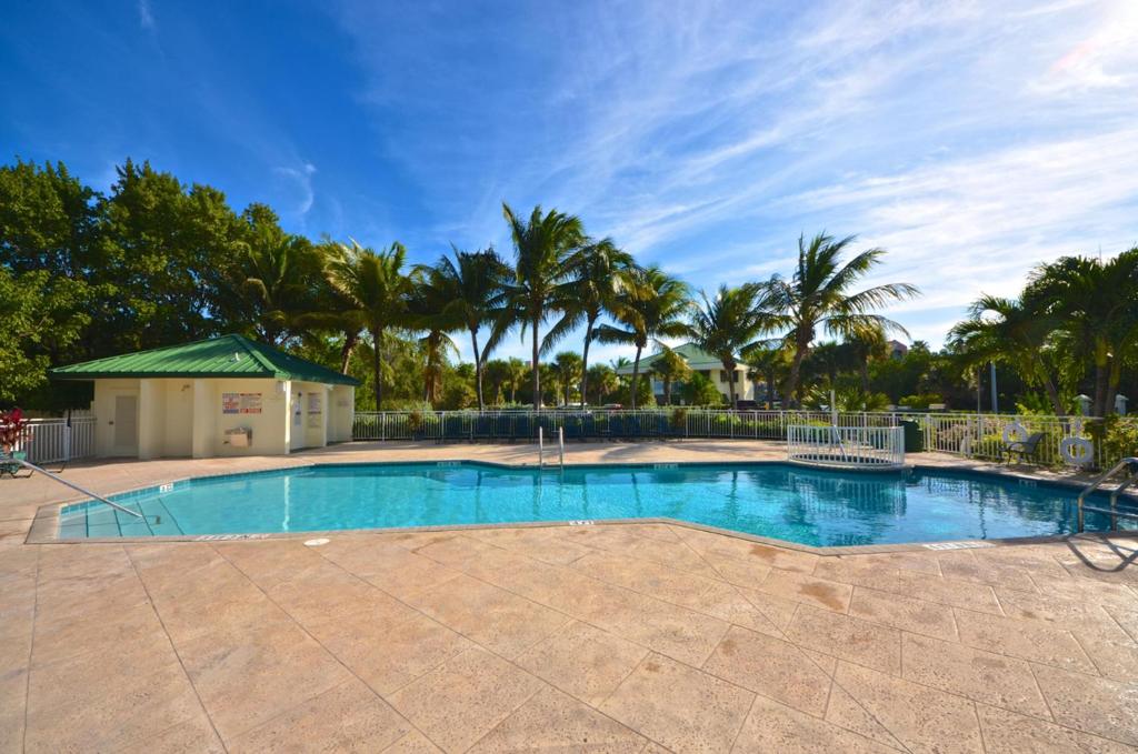 a large swimming pool with palm trees in the background at Sunrise Suites Big Kahuna Suite #202 in Key West