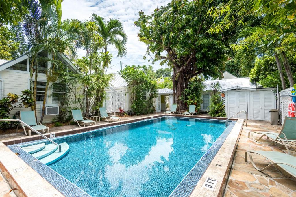 una piscina en el patio trasero de una casa con palmeras en Oceana Suite, en Key West