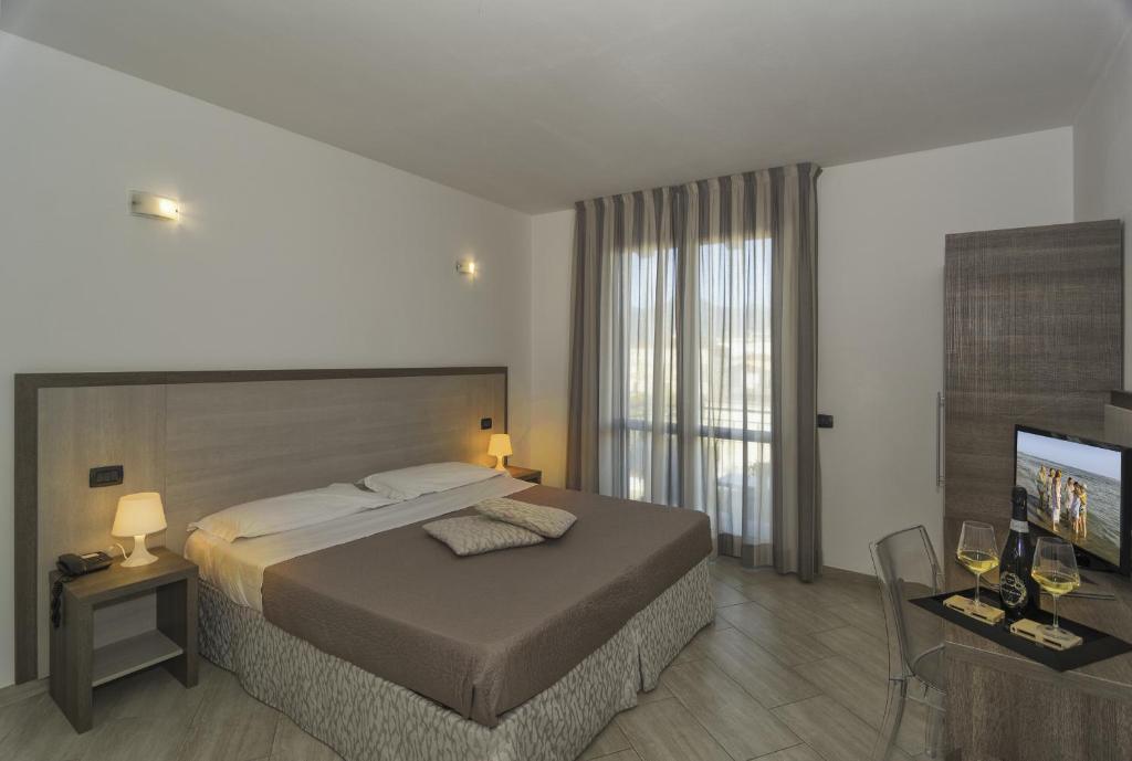 a bedroom with a bed and a flat screen tv at Hotel Lido Inn in Lido di Camaiore