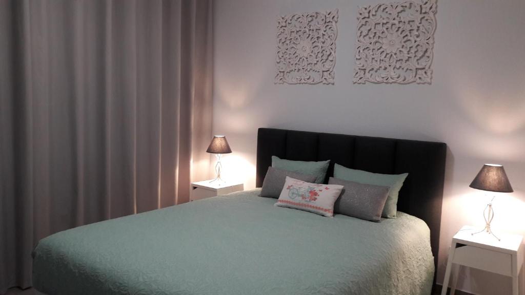 um quarto com uma cama com dois candeeiros em duas mesas em AL - BOA NOVA em Madalena
