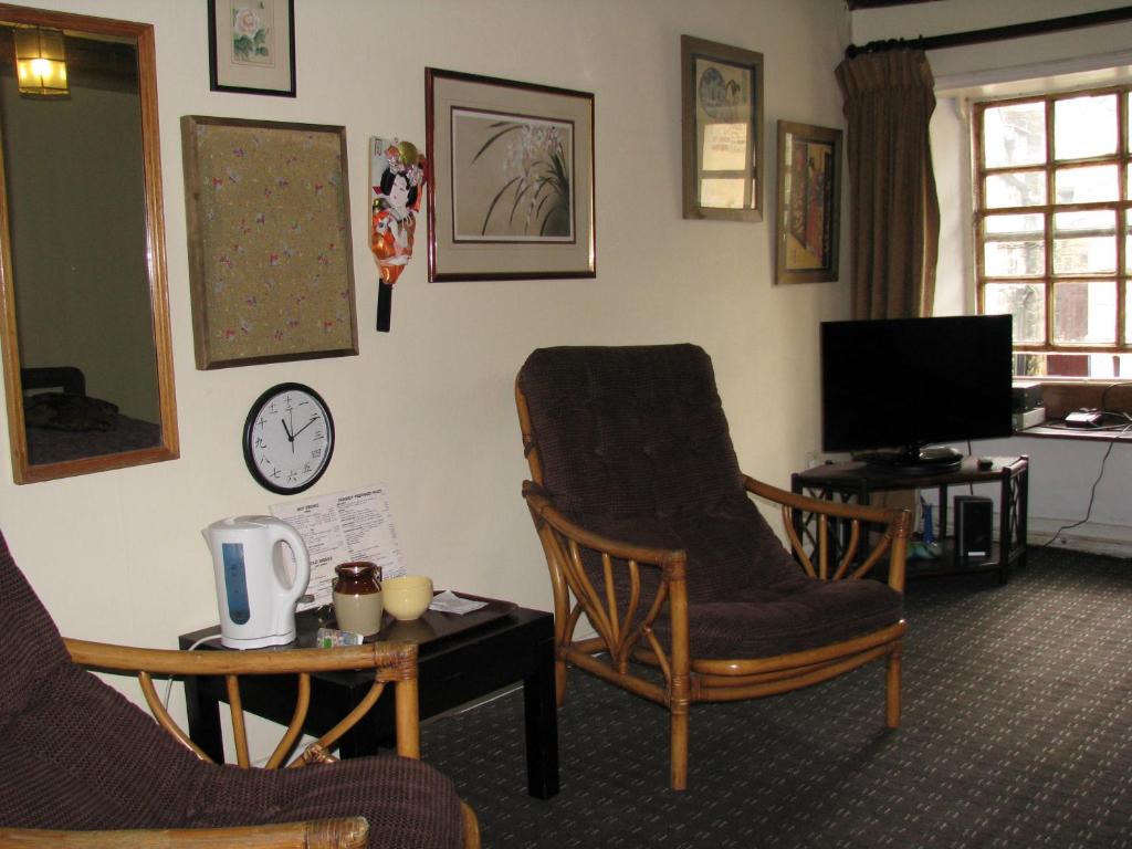 a living room with two chairs and a tv at Sweetheart House in Harrogate