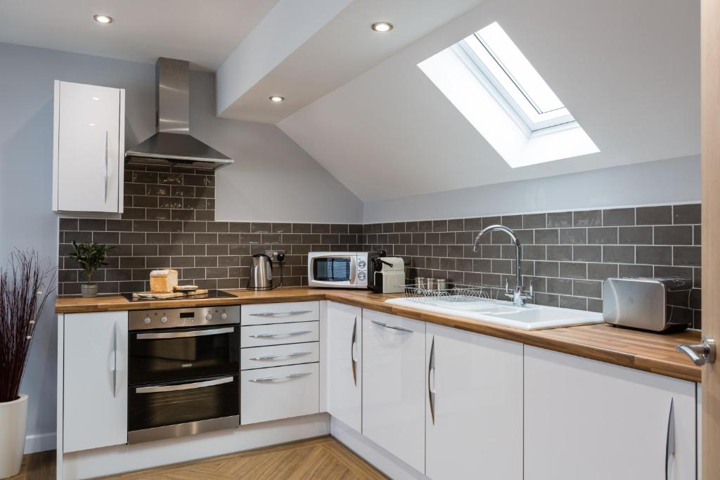 a kitchen with white cabinets and a skylight at The Apartments in Market Weighton