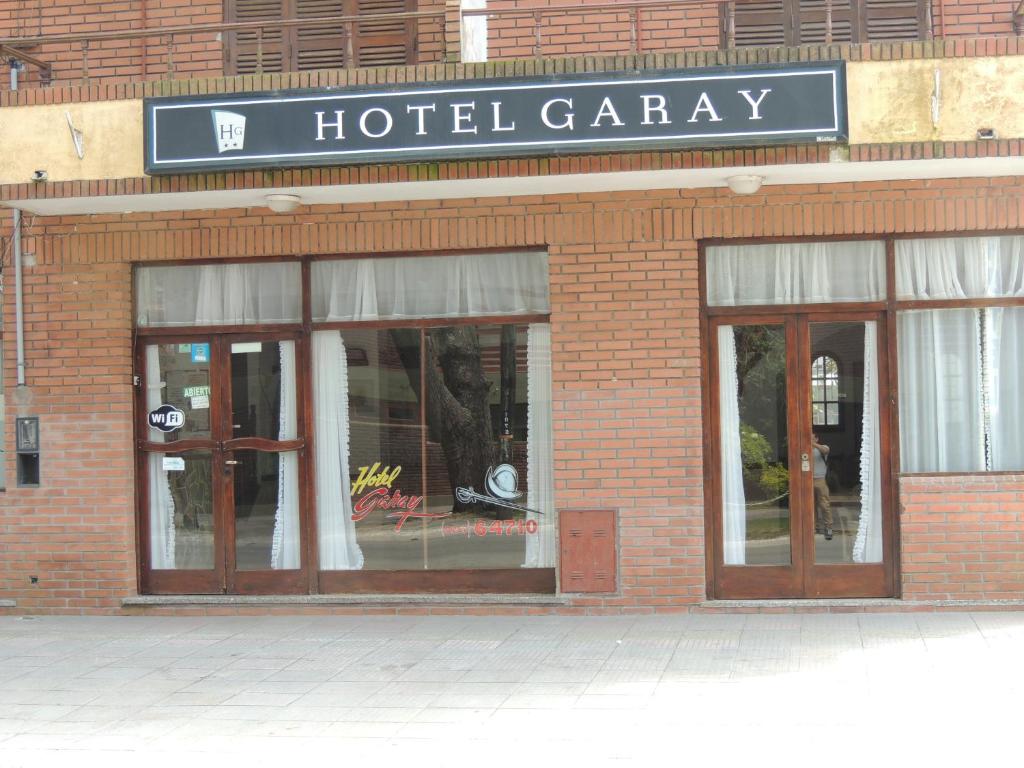 un garage de l'hôtel avec des portes en verre et un panneau sur celui-ci dans l'établissement Hotel Garay, à San Bernardo