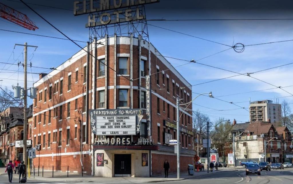 un grand bâtiment en briques avec un panneau sur son côté dans l'établissement Filmores Hotel, à Toronto