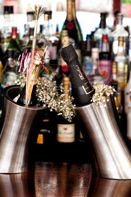 two silver vases with a bottle of wine on a bar at Villa Maraki in Agia Paraskevi