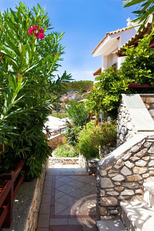 a garden with a stone walkway and a pink flower at Villa Maraki in Agia Paraskevi