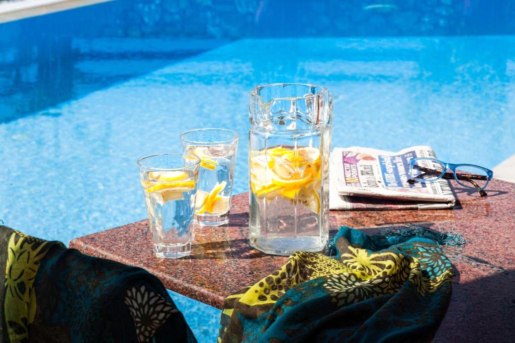 a glass of water and two glasses of water with lemon slices at Villa Maraki in Agia Paraskevi