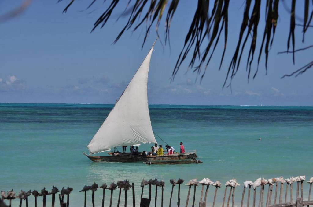 a group of people on a sail boat in the ocean at Mango Beach House in Jambiani