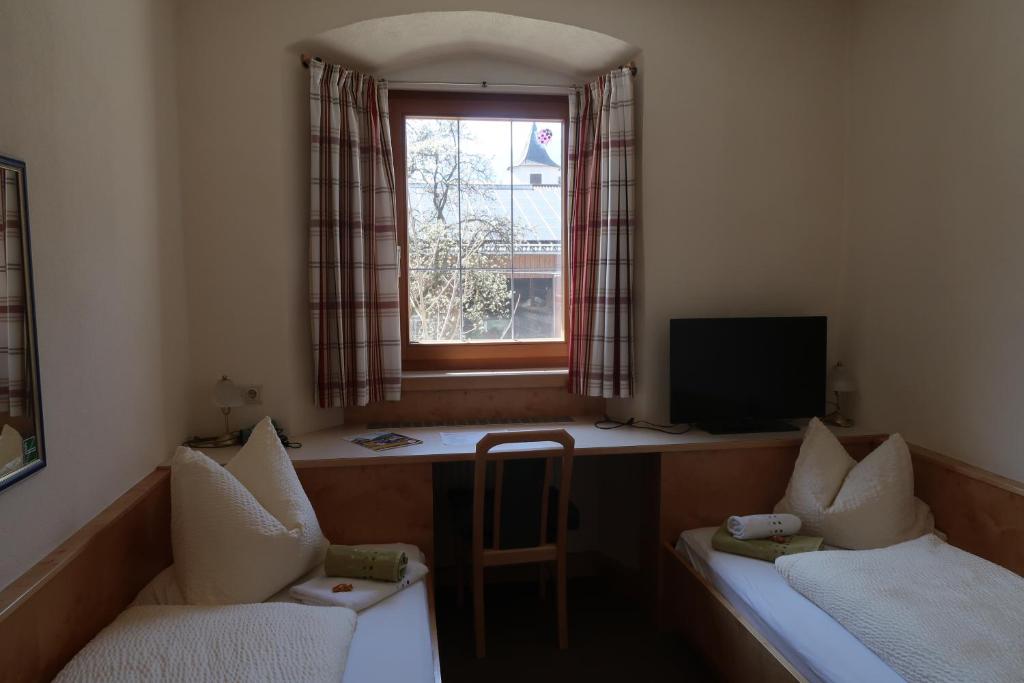 a small room with two chairs and a window at Hotel Garni Löwen in Silz