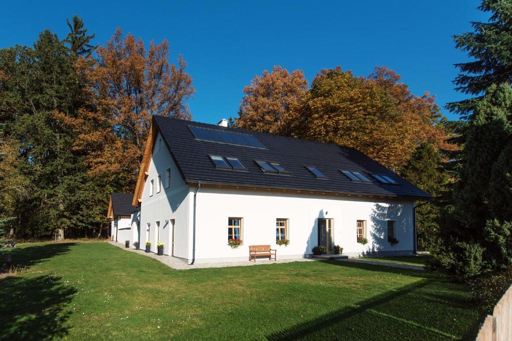 a white house with solar panels on its roof at Penzion Fořtovna in Častrov