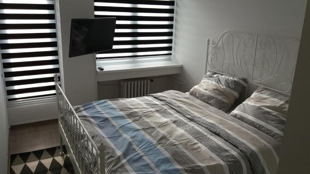 um quarto com uma cama, uma televisão e janelas em WHITE CITY 2 em Belgrado