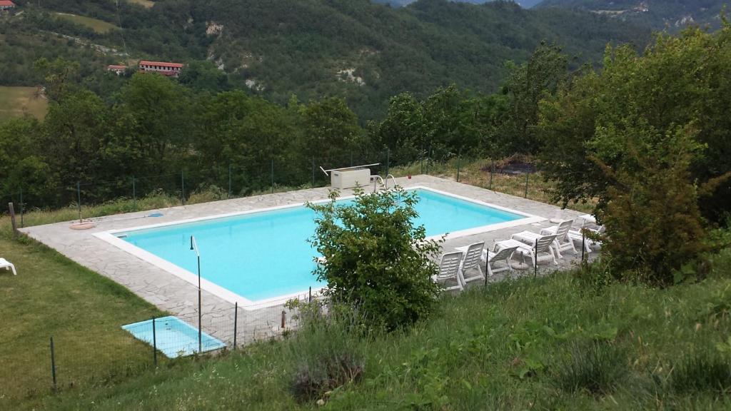 an image of a swimming pool with chairs around it at Agriturismo Le Piagge in Ponzone