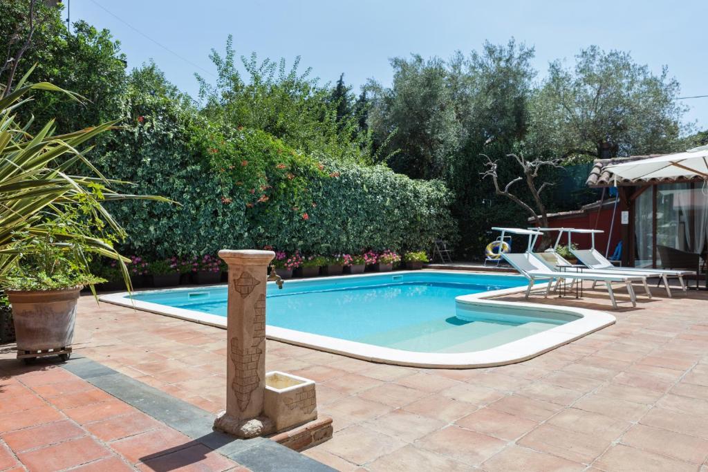 a swimming pool in a yard with a table and chairs at Villa Giovanna in Ragalna