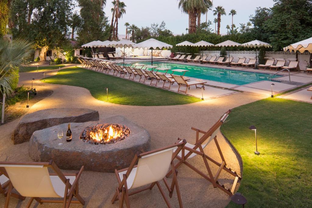 a pool with chairs and a fire pit in front of a resort at Ingleside Estate Hotel & Bungalows- Adults Only in Palm Springs