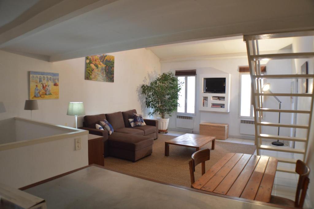 a living room with a couch and a table at Studio loft avec terrasse centre historique in Ajaccio