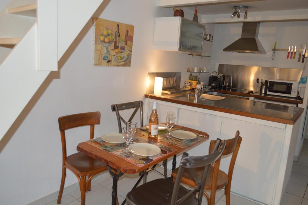 a kitchen with a wooden table and chairs and a counter at Studio loft avec terrasse centre historique in Ajaccio