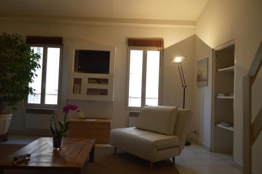 a living room with a chair and a table at Studio loft avec terrasse centre historique in Ajaccio