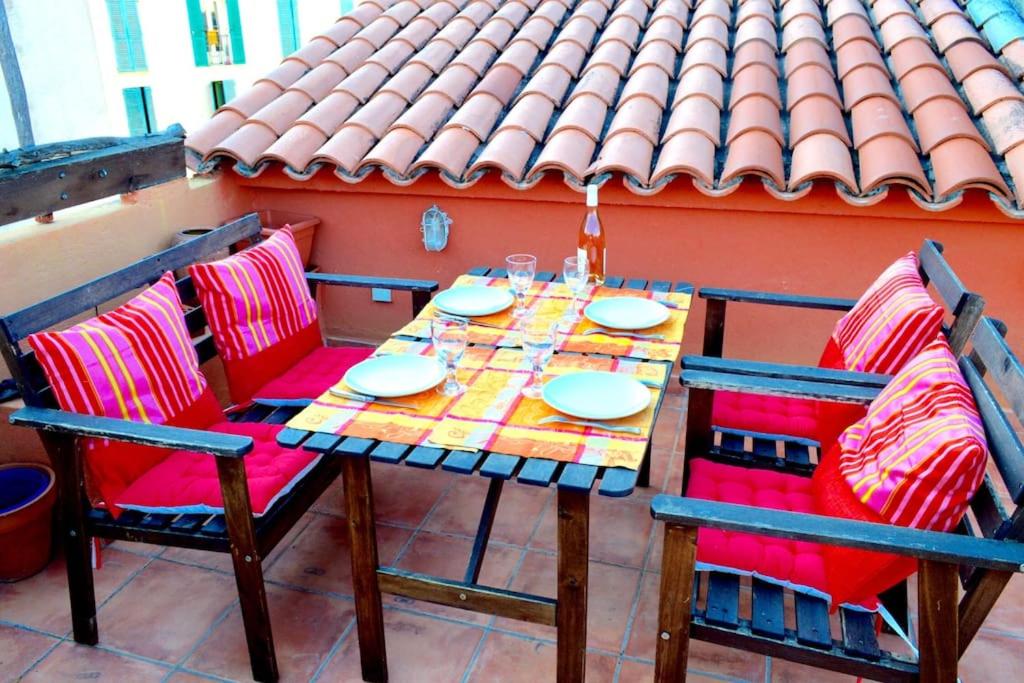 a table and chairs on a patio with a roof at Studio loft avec terrasse centre historique in Ajaccio