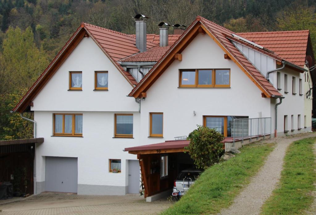 une maison blanche avec un toit rouge dans l'établissement Ferienwohnung Graf, à Lauf