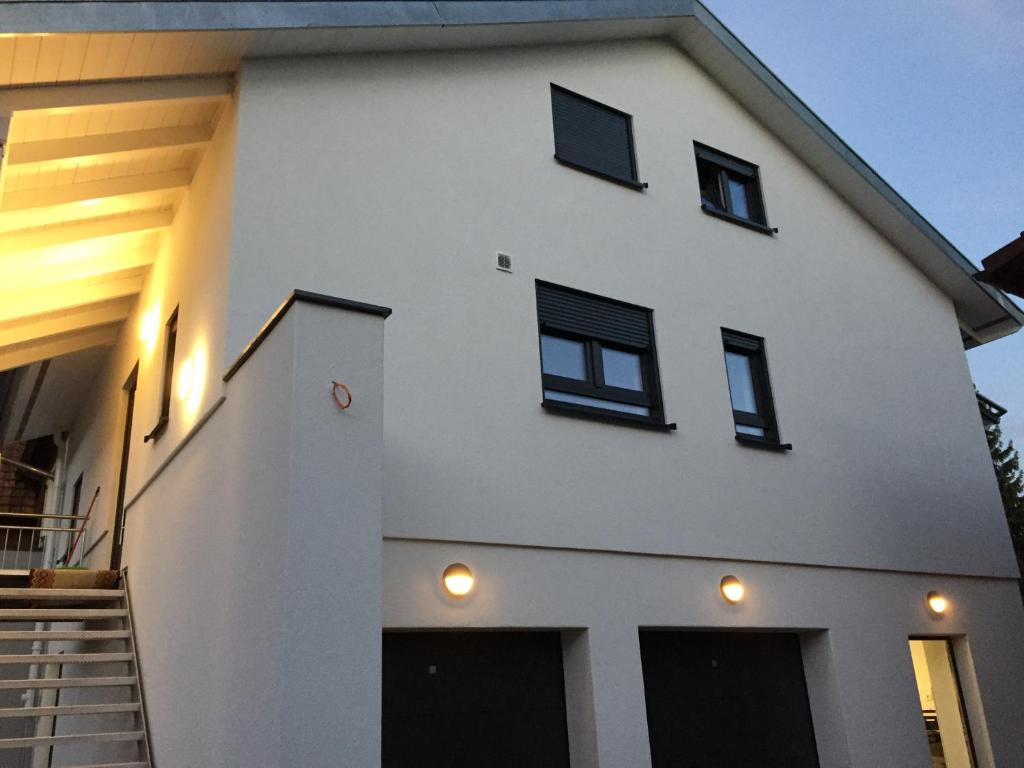 a white house with black windows and a staircase at Casa Perla Bianca in Rheinfelden