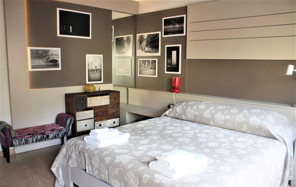 1 dormitorio con 1 cama y 1 silla y cuadros en la pared en Appartamento Via Mazzini en Rovigo