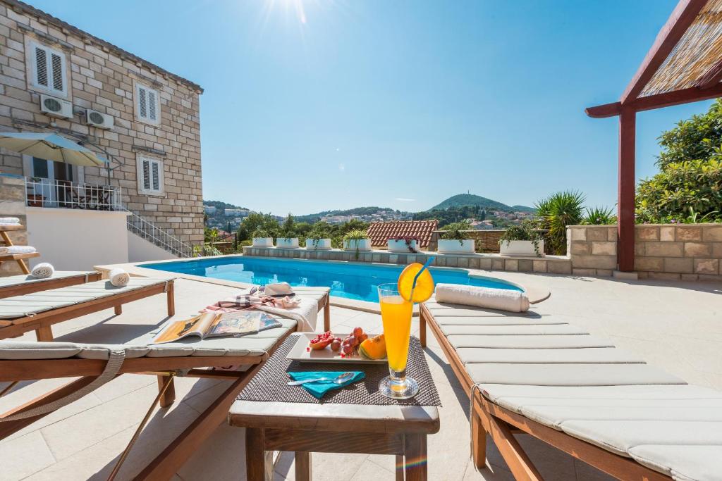 a patio with a table and a swimming pool at Apartments Miljas 2 in Dubrovnik