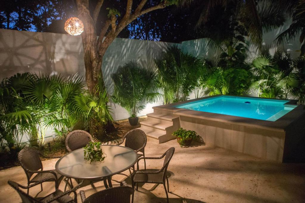 a patio with a table and chairs and a swimming pool at Cozy house downtown Cancun in Cancún