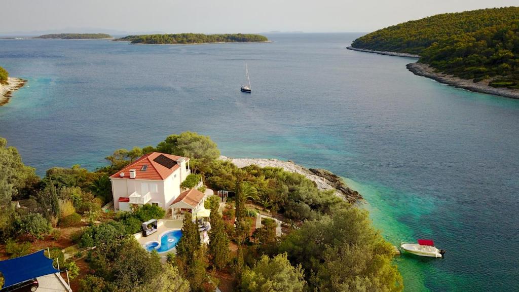 eine Insel mit einem Haus und einem Boot im Wasser in der Unterkunft Waterfront villa with pool in Vela Luka