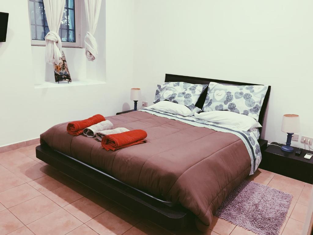 ローマにあるCasa delle Vittorieのベッドルーム1室(大型ベッド1台、赤い毛布、枕付)