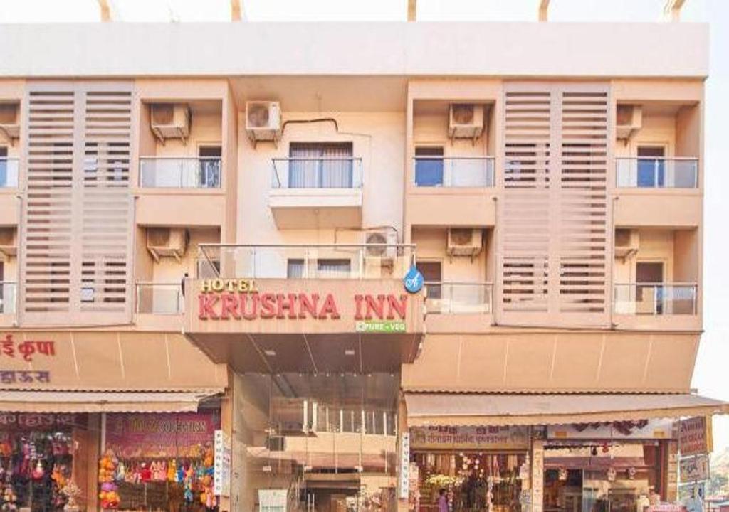 een groot gebouw met een bord ervoor bij Hotel Krushna Inn in Trimbak