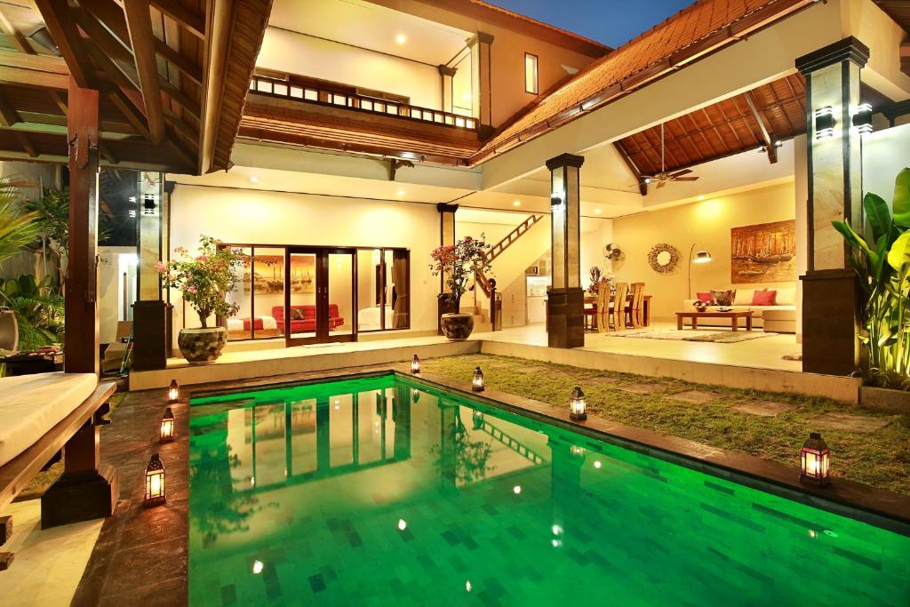 a swimming pool in the middle of a house at De Liza Villa Seminyak Beachside in Seminyak