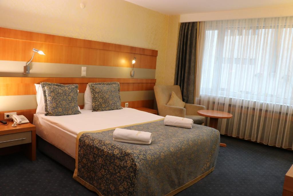 Postel nebo postele na pokoji v ubytování Burcman Hotel