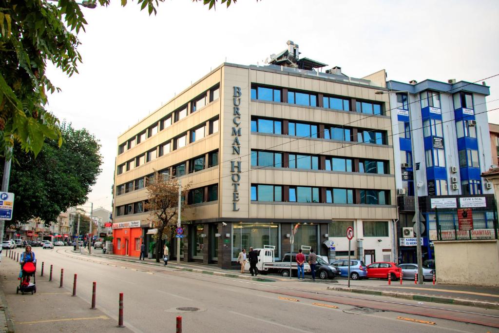 un edificio en una calle con coches aparcados delante en Burcman Hotel en Bursa