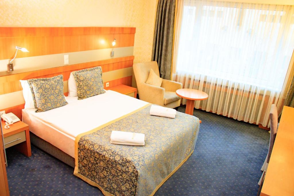 Postel nebo postele na pokoji v ubytování Burcman Hotel