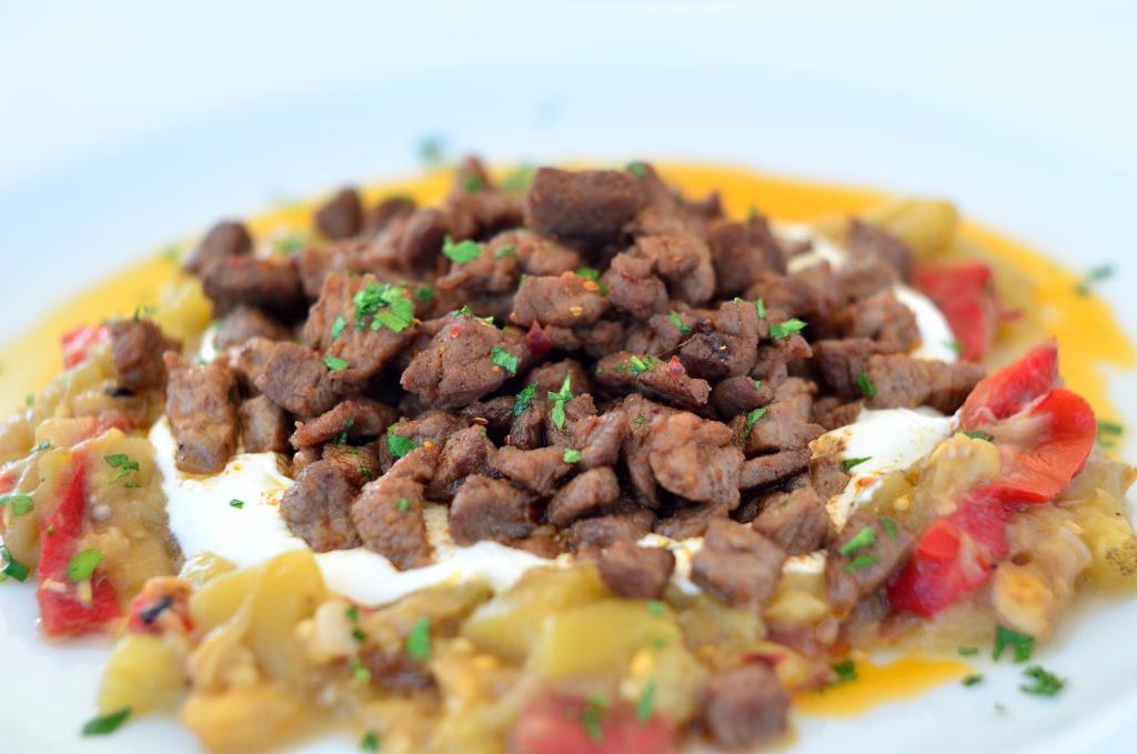 a plate of food with meat on top of food at Lugga Boutique Hotel & Beach in Ortakent