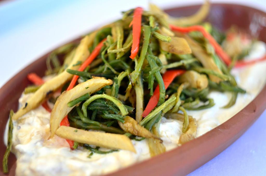 a bowl of food with vegetables on top of dip at Lugga Boutique Hotel & Beach in Ortakent